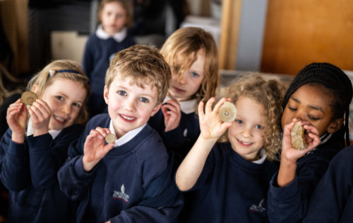 Group of school children holding fossils